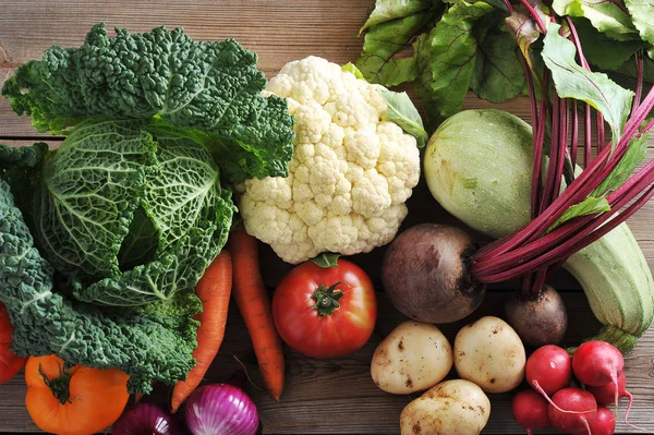 Vegetable set of fresh vegetables. Cauliflower, juicy carrots, Bulgarian pepper, ripe tomato, red onions, beets, zucchini, radish, young potatoes and head of savoy cabbage. Closeup. Macro photography.