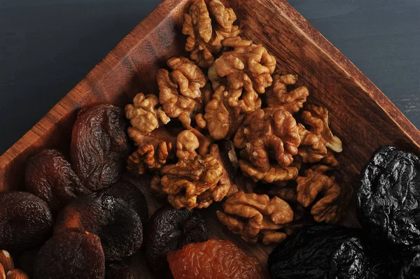 Kurutulmuş meyve ve fındık ile plaka. Çerçeve içinde kayısı, erik ve ceviz yerleştirilir bir plaka parçasıdır. Yukarıdan görüntüleyin. Close. Makro fotoğrafçılık.