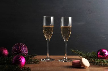 İki bardak şampanya ve iki makaron. Ladin dalları ve Noel topları kompozisyon bir Noel karakteri vermek. Close.