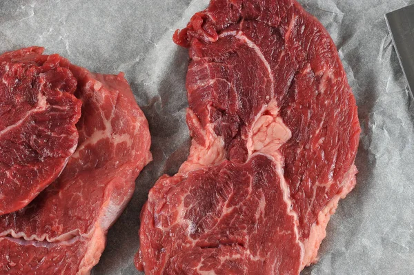 Parşömen kağıdında çiğ biftek. Yukarıdan görüntüleyin. Close. Makro fotoğrafçılık. 