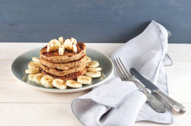Karabuğday krepleri diğerine serilir. Krepmuz dilimleri ile dekore edilmiş ve çikolata şurubu ile dökülür. Yemeğin yanında peçete ve çatal bıçak takımı var. Close. 