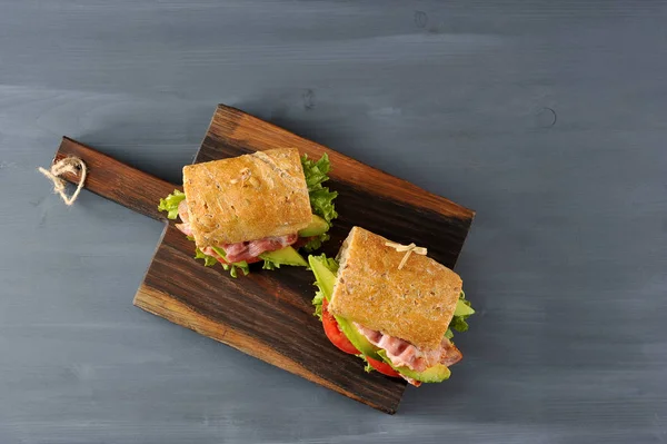 Сэндвич Багетом Начинкой Салата Ломтиками Жареного Бекона Помидорами Авокадо Сэндвич — стоковое фото
