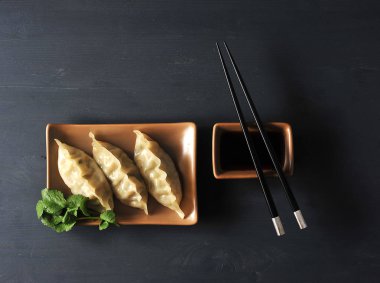 Damping - et, balık, sebze, deniz ürünleri çeşitli dolgular ile ince bir hamur dan çanak. Soya sosu ve yemek çubuklarına yakın. Karanlık arka plan. Close. Yukarıdan görüntüle.