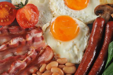 Bir tabak kızarmış pastırma, sosis, frited taze domates ve champignons, domates soslu beyaz fasulye, tost, kızarmış yumurta. Close. Yukarıdan görüntüleyin. Makro fotoğrafçılık.