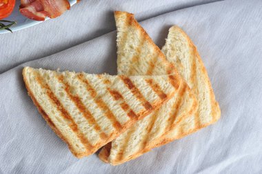 Birkaç dilim ızgara beyaz ekmek. Tost bir bez peçete üzerinde yatıyor. Close. Yukarıdan görüntüleyin. Makro fotoğrafçılık.