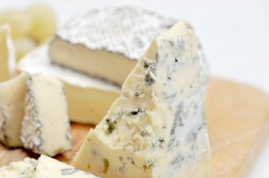 Peynir tabağı: küflü dorblu peynir, kamembert külleri, hafif ahşap tahta üzerinde brie. Beyaz arka plan. Close. Makro fotoğrafçılık.