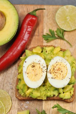 Avokado ve haşlanmış yumurta iki yarısı ile tost. Açık arka plan. Close. Yukarıdan görüntüleyin. Çerçevenin dikey yönü.