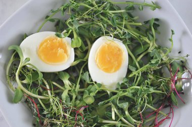 Çanak, bezelye, ayçiçeği ve yumuşak haşlanmış yumurta iki yarısı lahanası. Çerçeve çatal ve zeytinyağı bir şişe. Açık arka plan. Yukarıdan görüntüleyin. Close.