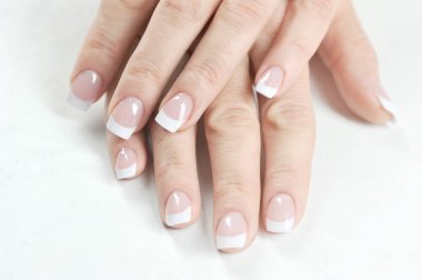 Fransız manikürlü iki kadın el. Close. Yukarıdan görüntüleyin. Beyaz arka plan.