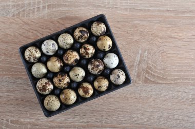 Yumurta koyu renkli özel bir tepsibıldı. Bütün hücreler meşgul. Açık ahşap arka plan. Close. Yukarıdan görüntüle.