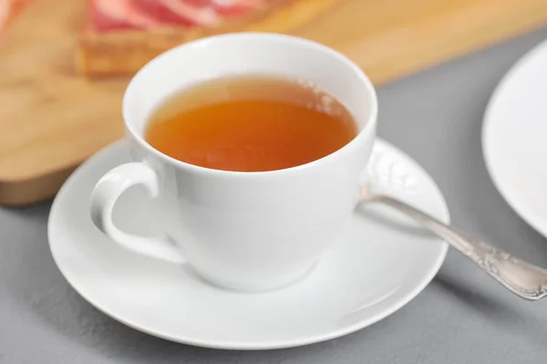 白杯配茶 在碟子上茶匙 背景是一个苹果派 浅色背景 — 图库照片