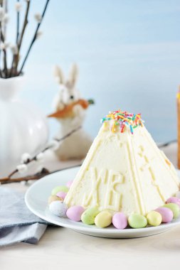 Geleneksel Paskalya köy peyniri tatlısı. Tatlının yan yüzeyinde İsa'nın dirilişi ile ilgili ifadenin xb harfi iki büyük harf vardır. Close. Dikey çekim.