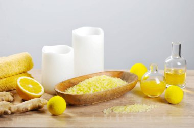 Lemon-ginger body scrub, bath salt, terry towel, oil and body cream. The composition is complemented by candles, half a lemon and ginger root. Light background. Close-up. clipart