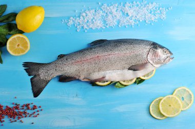 Atlantik büyük somon. Kafası olan somon balığı, harcanmış, pişmeye hazır. Balık yanında limon ve bireysel dilimler vardır. Tuz ve biber somonların etrafına serpilir. Yukarıdan görüntüleyin. Close.