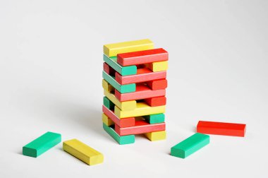 Çok renkli ahşap çubuklar kulesi. Bulmaca Kulesi. Beyaz arka plan. Close.