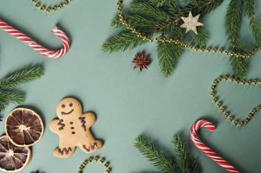 Noel kompozisyonu. Kompozisyon küçük bir kişi şeklinde zencefil çerezleri oluşur, karamel canes, ladin dalları, kuru portakal dilimleri, boncuk. Yukarıdan görüntüleyin. Close. Açık arka plan.