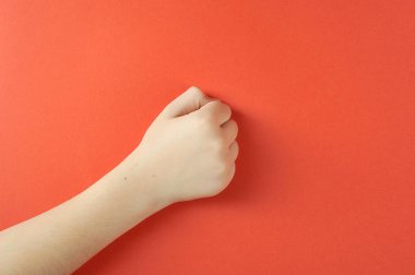 Çocukların eli yumruklara sokulmağa. Close. Kırmızı arka plan. Yukarıdan görüntüleyin. Metin için boş alan.
