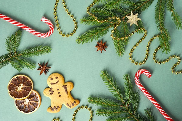 Noel kompozisyonu. Kompozisyon küçük bir adam şeklinde zencefil çerezleri içerir, karamel baston, ladin dal, çam kozalağı, anason. Beyaz arka plan. Yukarıdan görüntüleyin. Metnin altındaki boşluk.