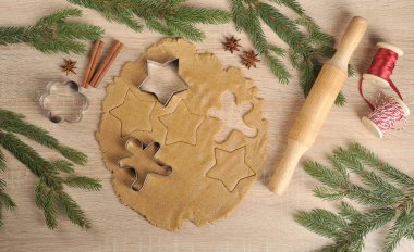 Noel kurabiyeleri pişiriyorum. Hamur ve kurabiye kesiciler. Ladin dalları, oklava, tarçın, anason kompozisyonu tamamlar. Close. Açık arka plan. Yukarıdan görüntüle.