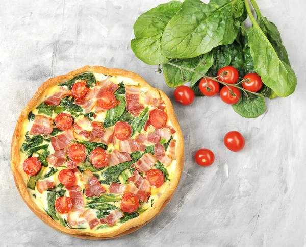 Klasik Fransız pasta kish. Krema, tavuk yumurtası, ıspanak ve pastırma ile dolum. Çerçevepeçende, yumurtalarda. bıçak ve kiraz domates. Yukarıdan görüntüleyin. Close.