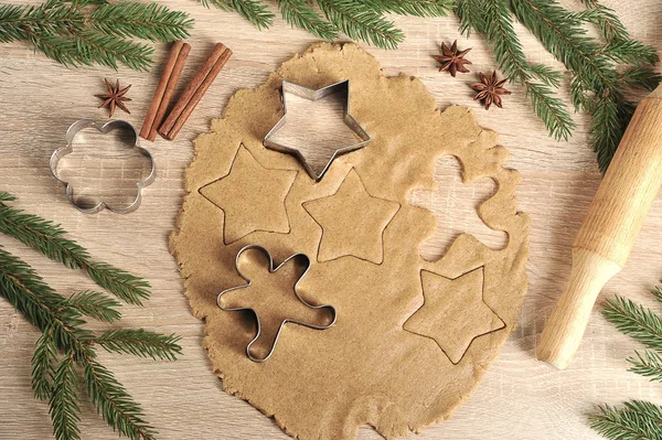 Noel kurabiyeleri pişiriyorum. Hamur ve kurabiye kesiciler. Ladin dalları, oklava, tarçın, anason kompozisyonu tamamlar. Close. Açık arka plan. Yukarıdan görüntüle.