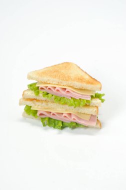 Jambon, peynir ve marul yaprakları ile klasik bir sandviç. Beyaz ekmek dilimleri kavrulur. Çerçevenin dikey yönü. Beyaz arka plan.