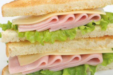 Beyaz ekmekten jambon ve peynirli sandviç. Sandviç çerçevenin alanını kaplar. Close. Makro fotoğrafçılık.