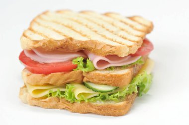 Kızarmış beyaz ekmekkulübü sandviçi. Sandviçin dolgusu peynir, jambon, olgun domates, taze salatalık ve marul yapraklarından oluşur. Beyaz arka plan. Close. Makro fotoğrafçılık.