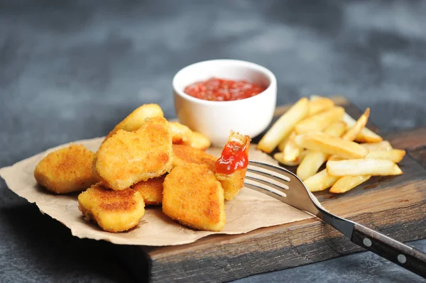 Kuřecí Nuggets Hranolky Dřevěné Desce Další Šálek Kečup Jeden Nugů — Stock fotografie