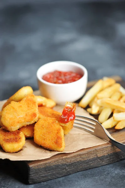 Kuřecí Nuggets Hranolky Dřevěné Desce Další Šálek Kečup Jeden Nugů — Stock fotografie