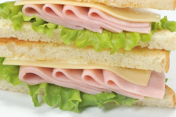 Beyaz ekmekten jambon ve peynirli sandviç. Sandviç çerçevenin alanını kaplar. Close. Makro fotoğrafçılık.