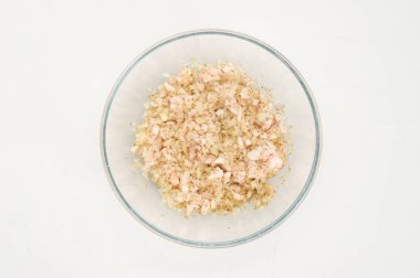 Derin bir kapta, soğan baharat ve yağ ile karıştırılır. Beyaz arka plan. Close. Yukarıdan görüntüle.