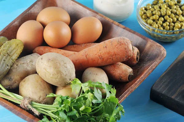 Salata olivier hazırlanması için ayarlayın. Tabakta haşlanmış yumurta, patates, havuç, salatalık turşusu, yeşillik. Mayonez konservesinin yanında, bir tabak bezelye ve haşlanmış sığır eti. Close. Makro fotoğrafçılık. 