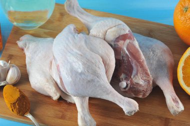 Portakal ile ördek pişirme için ayarlayın. Gemide çerçeve ördek bacak. Portakal, zerdeçal ve sarımsak yakın salamura hazırlık için. Mavi ahşap arka plan. Yukarıdan görüntüleyin. Close. Makro fotoğrafçılık.