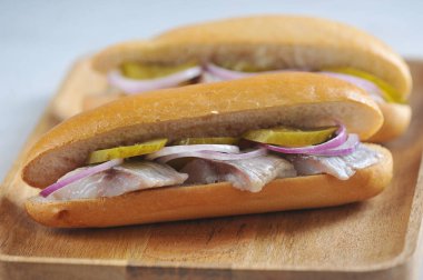 Ringa balığı, soğan, salatalık turşusu ile geleneksel Hollanda sandviçleri. Close. Makro çekimi. Açık arka plan. 