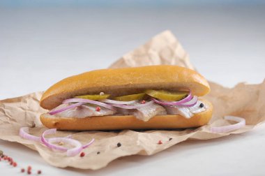 Ringa balığı, soğan ve salatalık turşusu ile geleneksel Hollanda sandviç. Açık arka plan. Close. Makro çekimi.