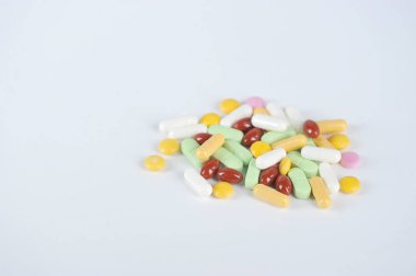 Farklı boyutlarda, şekillerde ve renklerde tablet şeklinde İlaçlar. Beyaz arka planda sözlü kullanım için tabletler. Metni yerleştirmek için boş alan.