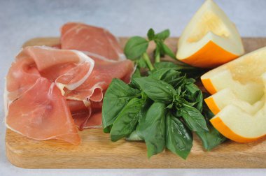 Kavun ile antipasto prosciutto. Bir demet taze fesleğen. Açık arka plan. Close.