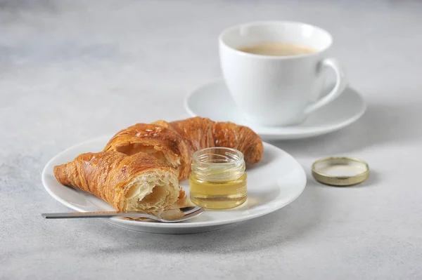 Croissant Talerzu Filiżankę Kawy Pobliżu Rogalika Słoik Miodu Zbliżenie Lekkie — Zdjęcie stockowe