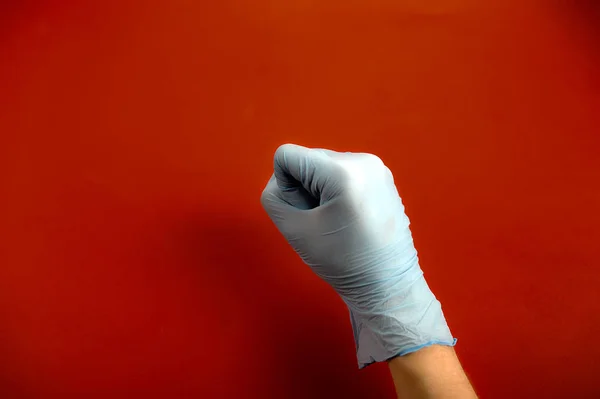 Отдай Медицинскую Латексную Перчатку Рука Сжалась Кулак Красный Фон Крупный — стоковое фото
