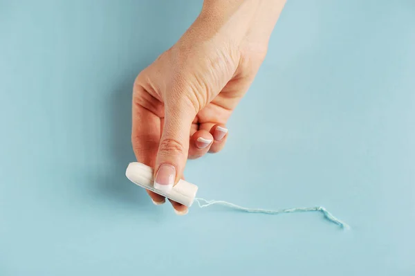 Higiénikus Tampon Női Kéz Ujjai Között Kék Háttér Közeli — Stock Fotó