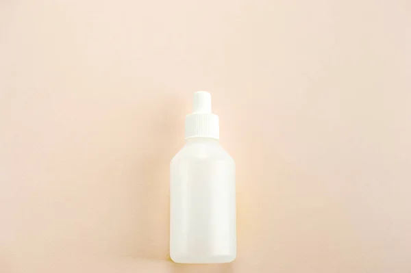 Plastic bottle with cap for medical liquids. Light background. Close-up. View from above.