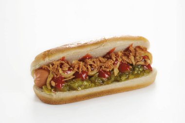 Beyaz arka planda hotdog. Hotdog dolması sosis, marul, domates dilimleri, salatalık salatası, kuru soğan, hardal ve ketçap oluşur. Close. Makro çekimi.