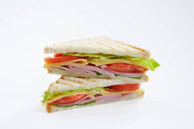 Beyaz ekmek sandviç jambon, peynir, domates dilimleri ve marul yaprakları ile doldurulmuş. Beyaz arka plan. Close.
