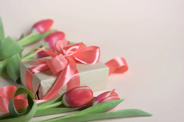 Tulpen Een Roze Achtergrond Naast Tulpen Geschenk Met Een Lint — Stockfoto