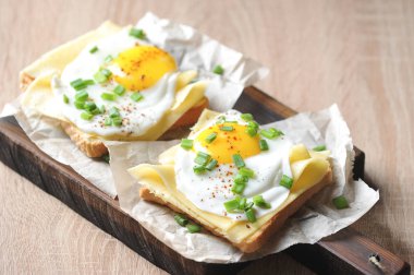 Kızarmış yumurta, peynir ve yeşil soğan ile tost. Sağlıklı beslenme kavramı. Açık arka plan. Close.