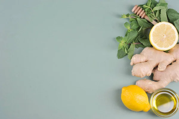 Ingredients for making a warming drink with ginger, mint and lemon.  Light background.  View from above.  Free space for text.