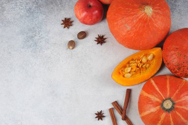 Hafif arka planda balkabakları. Bileşimi elmalar, tarçın ve hindistan cevizi ile tamamlanır. Metin için boş alan. Yukarıdan görüntüle.