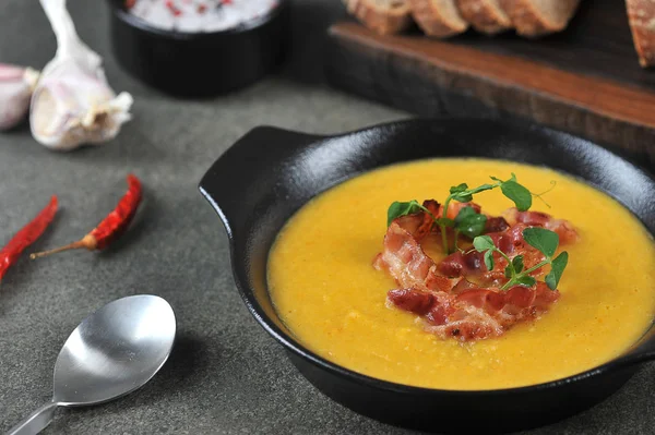 Pea cream soup with bacon. The soup is decorated with green pea sprouts. Dark background. Close-up. — Stock Image Pea Cream Soup Bacon Soup Decorated Green Pea Sprouts Dark Stock Picture