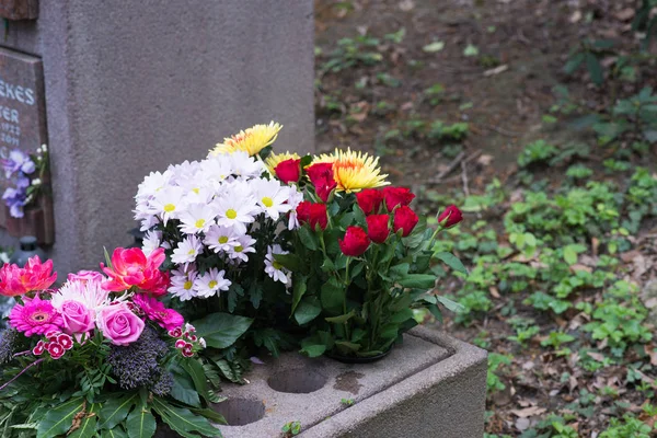 Viele Bunte Blumen Neben Einem Urnengrab lizenzfreie Stockbilder